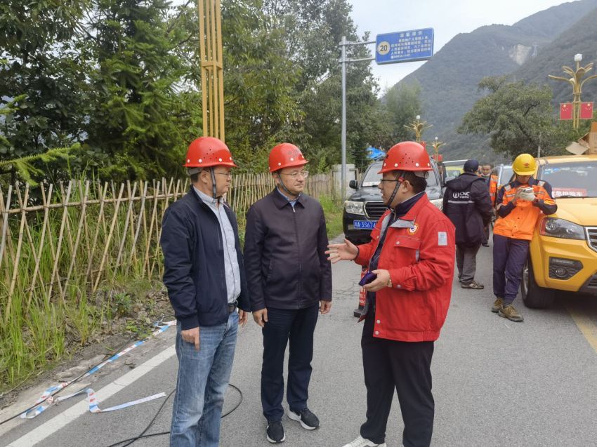 伍定聽(tīng)取前線技術(shù)人員作工作匯報(bào)。四川省地質(zhì)局供圖