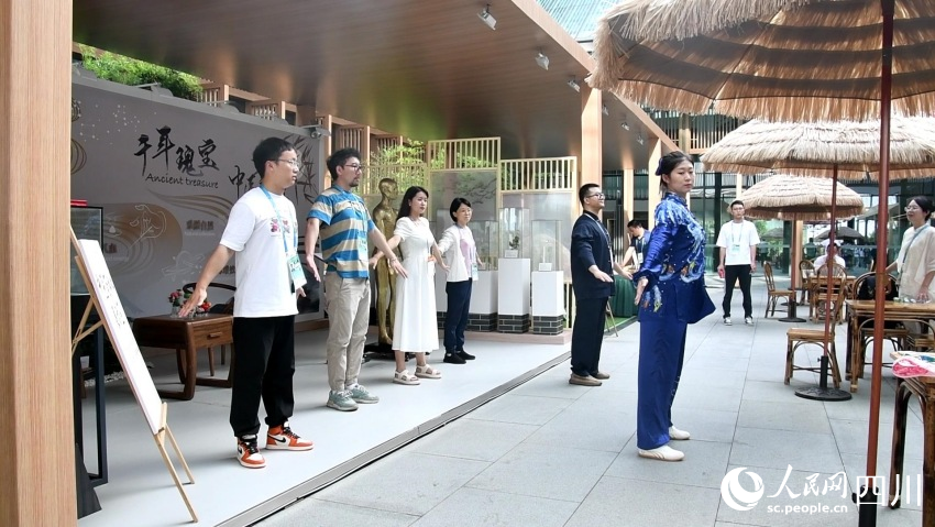 展示區(qū)工作人員正在帶領(lǐng)參觀者體驗(yàn)八段錦。人民網(wǎng)記者 王洪江攝