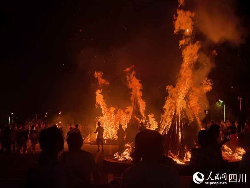 市民點(diǎn)燃火把祈福。王一攝