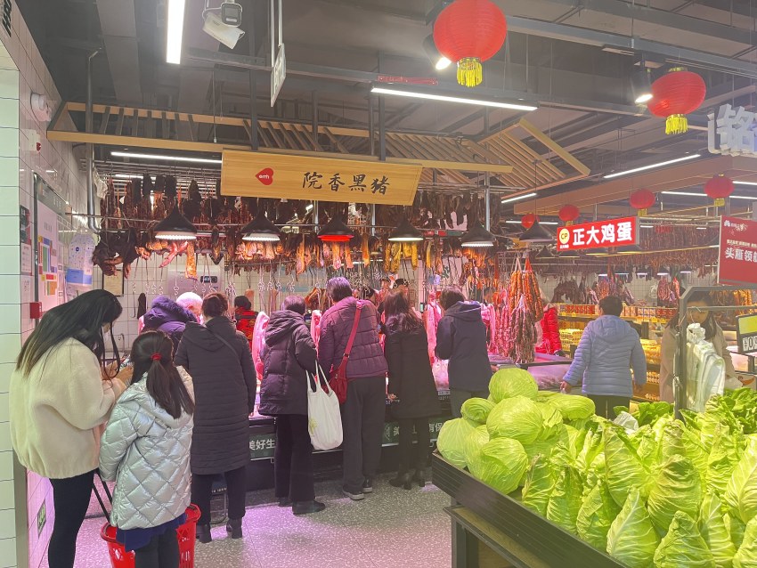 益民菜市東苑店內(nèi)，市民正在買菜，攤點(diǎn)上擺滿了蔬菜。益民菜市供圖