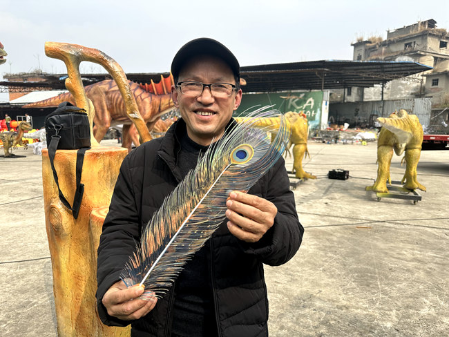 劉俊才和他剪制的“雀之靈”羽毛。人民網(wǎng)記者 王波攝