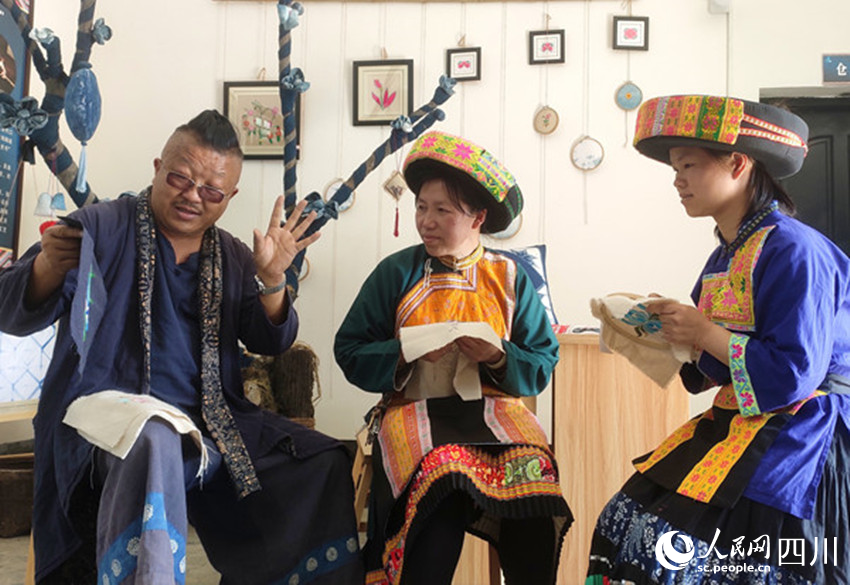 楊安平在講解蠟染技藝。曾剛攝