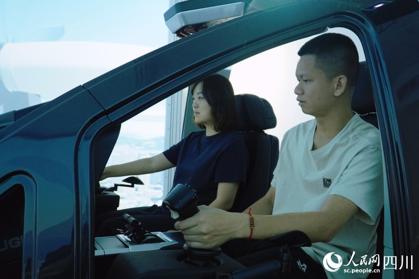記者在AE200型“飛行汽車”模擬艙內(nèi)進(jìn)行體驗(yàn)。人民網(wǎng) 趙祖樂攝