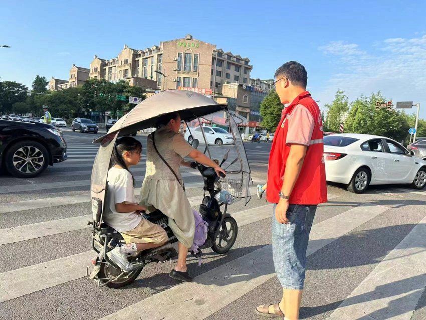 程平在開展文明交通勸導。都江堰市融媒體中心供圖