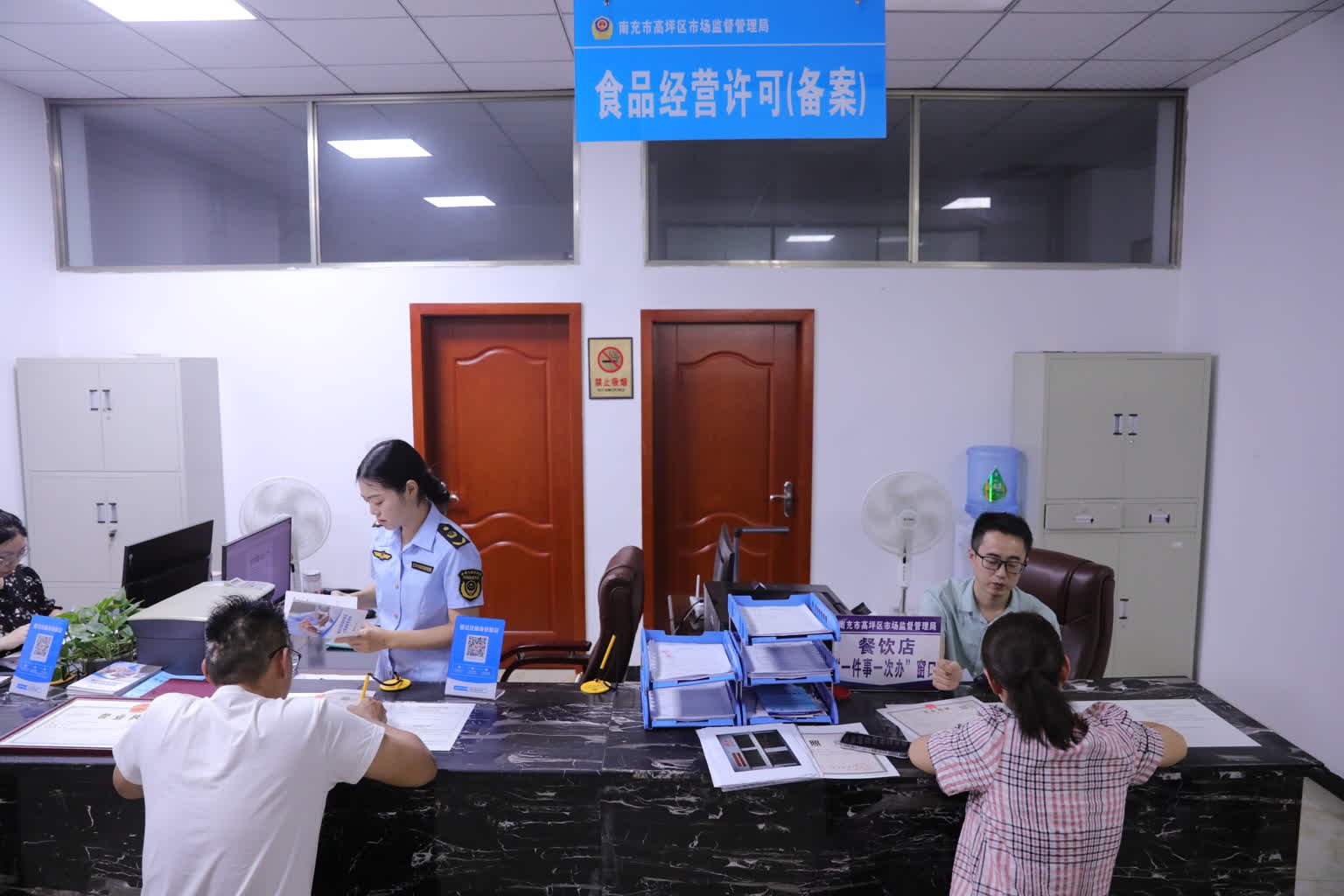 在高坪區(qū)白塔市場(chǎng)監(jiān)管所，工作人員正在為申辦人辦理食品經(jīng)營(yíng)許可證。高坪區(qū)融媒體中心供圖