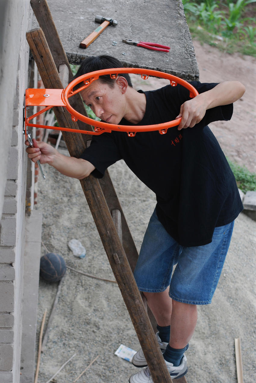 2010年5月30日，王斌給吳波安裝新籃筐。王斌供圖