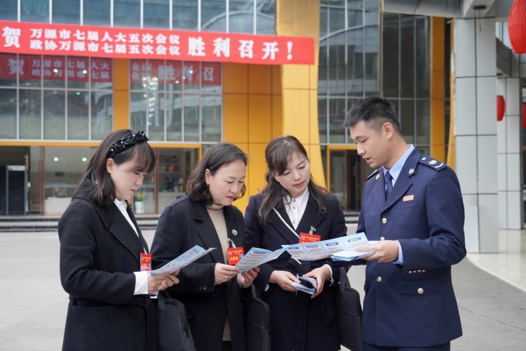 稅務(wù)干部向萬源“兩會(huì)”代表宣傳稅費(fèi)政策。萬源市稅務(wù)局供圖