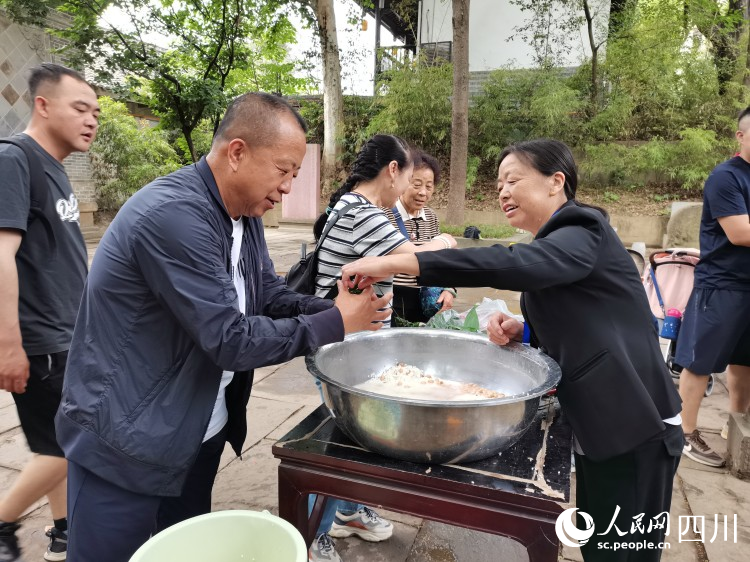 工作人員正在指導(dǎo)游客包粽子。李建生攝