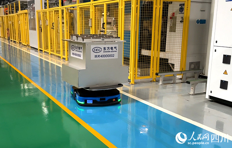 AGV智能無人運輸小車馱著超過自身體積數(shù)倍的待加工材料穿梭在車間內(nèi)。張越攝