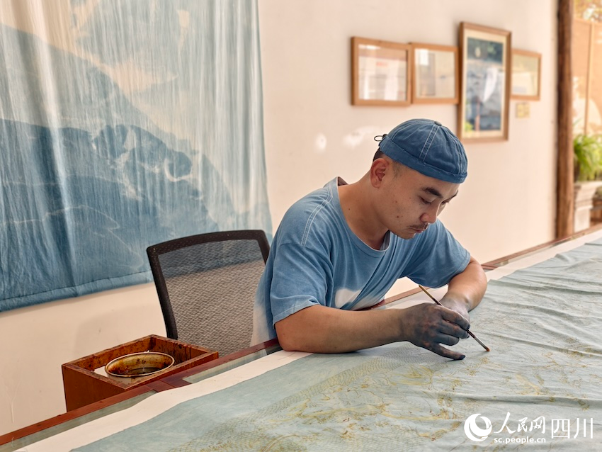 謝寶高正在進(jìn)行蠟染藝術(shù)創(chuàng)作。人民網(wǎng)記者 郭瑩攝