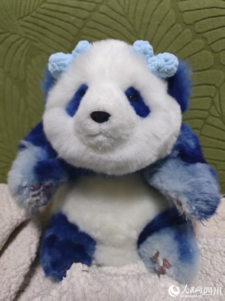 蠟染工坊和文創(chuàng)企業(yè)聯(lián)名推出的熊貓玩偶文創(chuàng)產(chǎn)品。人民網(wǎng)記者 郭瑩攝